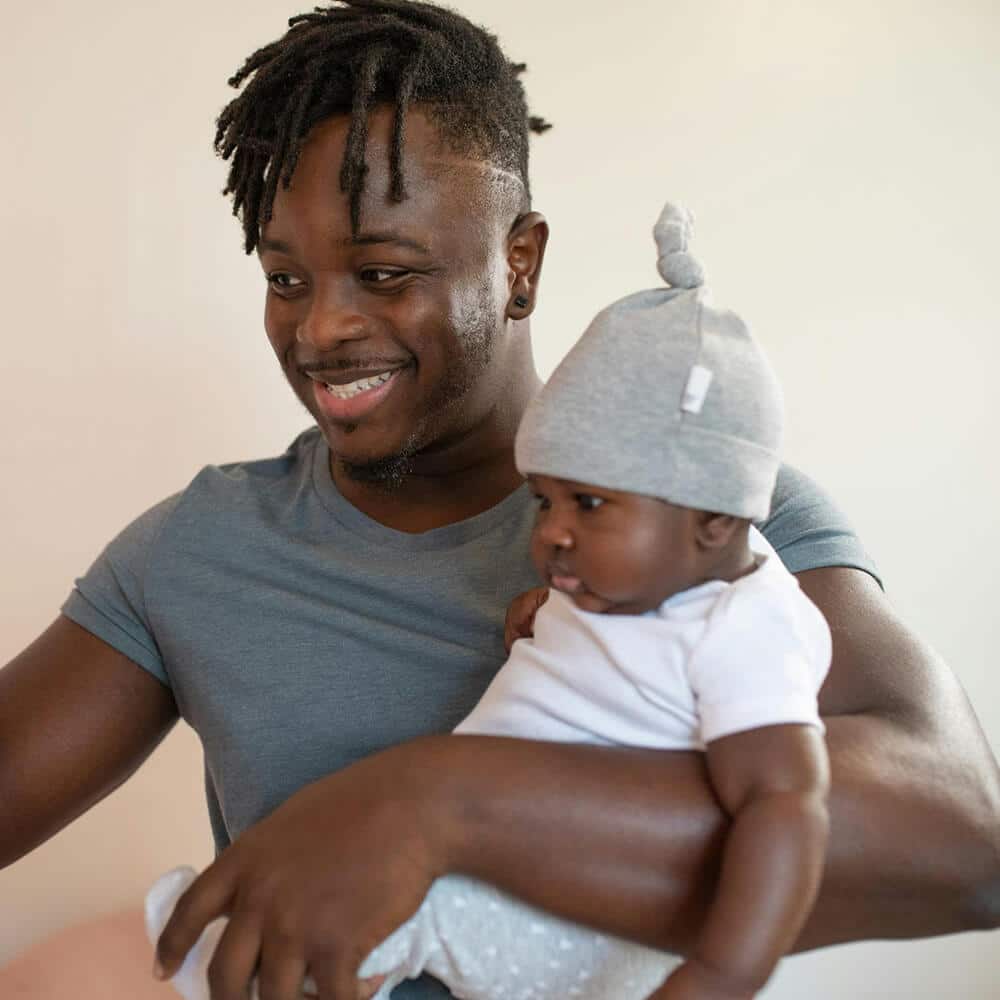 Man gently holding a baby, conveying care and support, representing the nurturing and compassionate environment of individual counselling.
